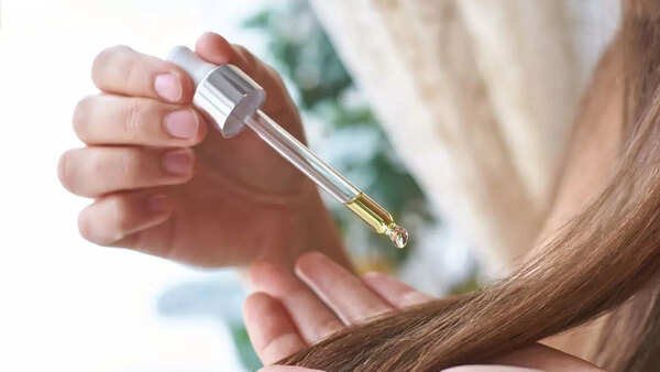 Woman applying hair serum to her freshly washed hair