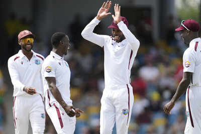 Roston Chase celebrates a wicket with Shamar Joseph