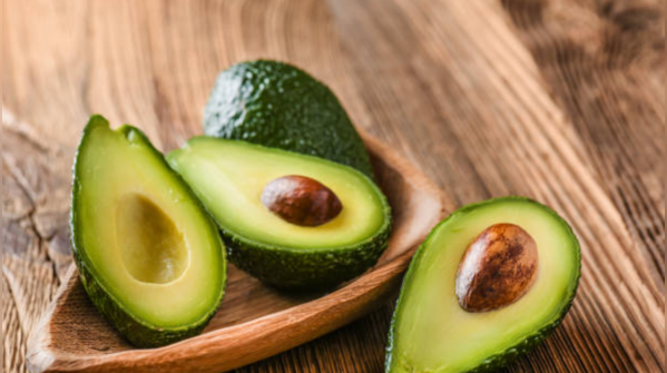 Avocado cut in half, showcasing its vibrant green color and healthy fats.