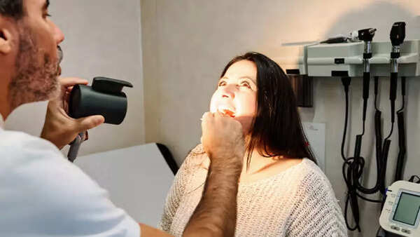 Doctor examining a patient for oral cancer